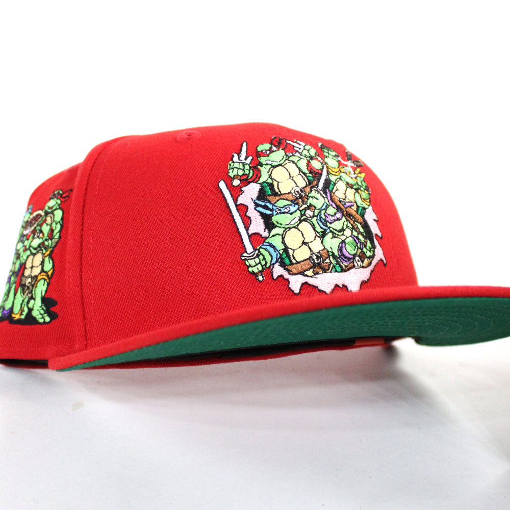 https://www.ecapcity.com/cdn/shop/products/the-teenage-mutant-ninja-turtles-new-era-59fifty-fitted-hat-_red-green-under-brim_-1.jpg?v=1605709537